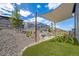 A low maintenance backyard features a play area, a fire pit area, and a shade sail for outdoor comfort at 8517 Eckley St, Littleton, CO 80125