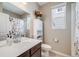 Bathroom with floral shower curtain, white vanity, and abundant natural light from the window at 8517 Eckley St, Littleton, CO 80125