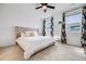 Airy bedroom with a tufted headboard, floral curtains, and a ceiling fan at 8517 Eckley St, Littleton, CO 80125