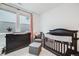 This Bedroom features a dark wood crib, changing table, and a comfortable gray chair, perfect for a new baby at 8517 Eckley St, Littleton, CO 80125