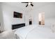 Bright bedroom with a white duvet, black TV console, and view to the bathroom and kitchen at 8517 Eckley St, Littleton, CO 80125