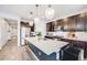 Modern kitchen with a large island, stainless steel appliances, and dark wood cabinetry at 8517 Eckley St, Littleton, CO 80125