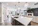 Open kitchen with a spacious island, pendant lights, and a view to the dining and living areas at 8517 Eckley St, Littleton, CO 80125