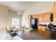 Bright kitchen featuring wooden cabinets, black appliances, and an island with bar seating and a stainless sink at 9585 Pearl Cir # 203, Parker, CO 80134