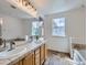 Bathroom with double sinks, neutral tile countertops, and a large mirror at 5155 W Quincy Ave # J103, Denver, CO 80236