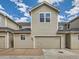 Exterior view of townhouse with garage and siding, showcasing the home's facade under a blue sky at 5155 W Quincy Ave # J103, Denver, CO 80236