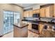 Efficient kitchen layout with stainless steel appliances, island, and sliding glass doors to patio at 5155 W Quincy Ave # J103, Denver, CO 80236