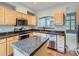 Well-equipped kitchen with an island, granite countertops, and a stainless steel dishwasher at 5155 W Quincy Ave # J103, Denver, CO 80236