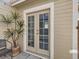 Inviting patio area with double doors, plant, and chair, creating a relaxing outdoor space at 5155 W Quincy Ave # J103, Denver, CO 80236