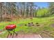Picturesque backyard with mature trees, open lawn space, a fire pit, and an outdoor grill for outdoor enjoyment at 30690 Highway 72, Golden, CO 80403