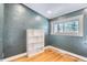 Bright bedroom with hardwood floors, a large window with view of trees, and a built-in bookshelf at 30690 Highway 72, Golden, CO 80403