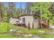 Charming tan home exterior with a cozy deck and grill surrounded by lush greenery at 30690 Highway 72, Golden, CO 80403