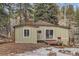 Cozy cottage-style home featuring a wooden deck, chimney, and picturesque outdoor living space at 30690 Highway 72, Golden, CO 80403