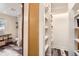 Hallway with a closet, shelving, and a view to the bathroom with patterned flooring and shelves at 30690 Highway 72, Golden, CO 80403