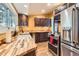 Bright kitchen featuring wood counters, dark cabinets, stainless steel appliances and hardwood floors at 30690 Highway 72, Golden, CO 80403