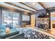 Comfortable living room featuring stone fireplace and wood beam ceilings at 30690 Highway 72, Golden, CO 80403