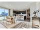 Sunlit dining room with modern table, adjacent to a kitchen featuring dark cabinets and stainless appliances at 14127 Deertrack Ln, Parker, CO 80134