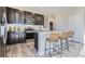 Well-lit kitchen features dark wood cabinetry, stainless appliances, white subway tile backsplash, and island with seating at 14127 Deertrack Ln, Parker, CO 80134