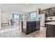 Open-concept kitchen with stainless appliances, dark wood cabinets, and views into the adjacent living and dining areas at 14127 Deertrack Ln, Parker, CO 80134