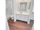 Clean bathroom with white vanity, a shower, and wood-look flooring at 2354 S Troy St, Aurora, CO 80014