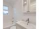Clean, all-white bathroom with tiled walls, tub, vanity, and natural light at 1474 Clayton St, Denver, CO 80206