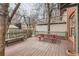 Large wooden deck features a red picnic table and bench seating, perfect for outdoor enjoyment at 1474 Clayton St, Denver, CO 80206