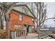 A red brick house features a wooden deck perfect for outdoor grilling and recreation at 1474 Clayton St, Denver, CO 80206