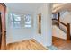 Sunlit foyer with hardwood floors, a decorative window, and access to the staircase at 1474 Clayton St, Denver, CO 80206