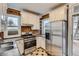 Well-lit kitchen featuring stainless steel appliances, brick accent wall, and ample cabinet space at 1474 Clayton St, Denver, CO 80206