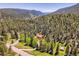 Stunning aerial view of a home nestled in a dense forest, showcasing the privacy and natural beauty of the property at 11768 Black Hawk Dr, Conifer, CO 80433