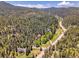 Expansive aerial view of multiple homes in a densely wooded area, highlighting the community's serene and natural setting at 11768 Black Hawk Dr, Conifer, CO 80433