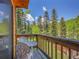 Outdoor balcony with chairs overlooking the surrounding trees and blue sky at 11768 Black Hawk Dr, Conifer, CO 80433