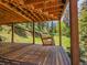 Covered deck featuring a wooden porch swing hanging with chains that overlook the lush backyard at 11768 Black Hawk Dr, Conifer, CO 80433