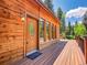 Charming wooden home exterior with a front door featuring decorative glass windows and a deck at 11768 Black Hawk Dr, Conifer, CO 80433