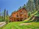Exterior of a stunning home featuring multiple decks surrounded by lush greenery at 11768 Black Hawk Dr, Conifer, CO 80433