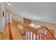 Hallway overlooking the living room with hardwood floors and wood banister at 11768 Black Hawk Dr, Conifer, CO 80433