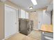 Bright laundry room featuring modern washer and dryer units, white cabinets and tile floors at 11768 Black Hawk Dr, Conifer, CO 80433