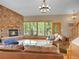 Comfortable living room with a stone fireplace, large windows, and leather sofas, perfect for relaxation at 11768 Black Hawk Dr, Conifer, CO 80433