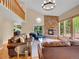 Elegant living room with a stone fireplace, wood floors, vaulted ceilings, and a cozy seating arrangement at 11768 Black Hawk Dr, Conifer, CO 80433