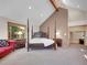 Spacious main bedroom featuring a large four-poster bed, vaulted ceilings, and a cozy sitting area at 11768 Black Hawk Dr, Conifer, CO 80433