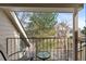 Balcony overlooking green trees and nearby buildings with chairs and small table at 4824 E Kentucky Ave # F, Denver, CO 80246