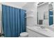 Bathroom with white sink and toilet and blue shower curtain at 4824 E Kentucky Ave # F, Denver, CO 80246