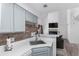 Well-lit kitchen with stainless steel sink, brick wall accent, and white cabinets at 4824 E Kentucky Ave # F, Denver, CO 80246