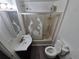 Bathroom with a shower over the bathtub, toilet, vinyl floor, and sink at 1272 N Ulster St, Denver, CO 80220