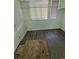 A small empty bedroom features wood-look floors and natural light from a window covered with blinds at 1272 N Ulster St, Denver, CO 80220