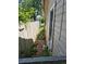 Narrow side yard with dirt ground along the side of a beige house with a wooden fence at 1272 N Ulster St, Denver, CO 80220