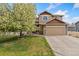 Inviting two-story home with a well-manicured lawn and a blossoming tree at 5452 Rustic Ave, Firestone, CO 80504