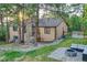 Spacious backyard with a stone fire pit, outdoor seating, and a view of a tan home surrounded by trees at 9416 Mcshane Ct, Parker, CO 80134