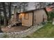 Tan home with a brick chimney, surrounded by mature trees, including a view of the deck and yard at 9416 Mcshane Ct, Parker, CO 80134