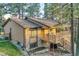 Exterior angled view of a brown home with brick accents, wooden deck with stairs, and surrounding mature trees at 9416 Mcshane Ct, Parker, CO 80134